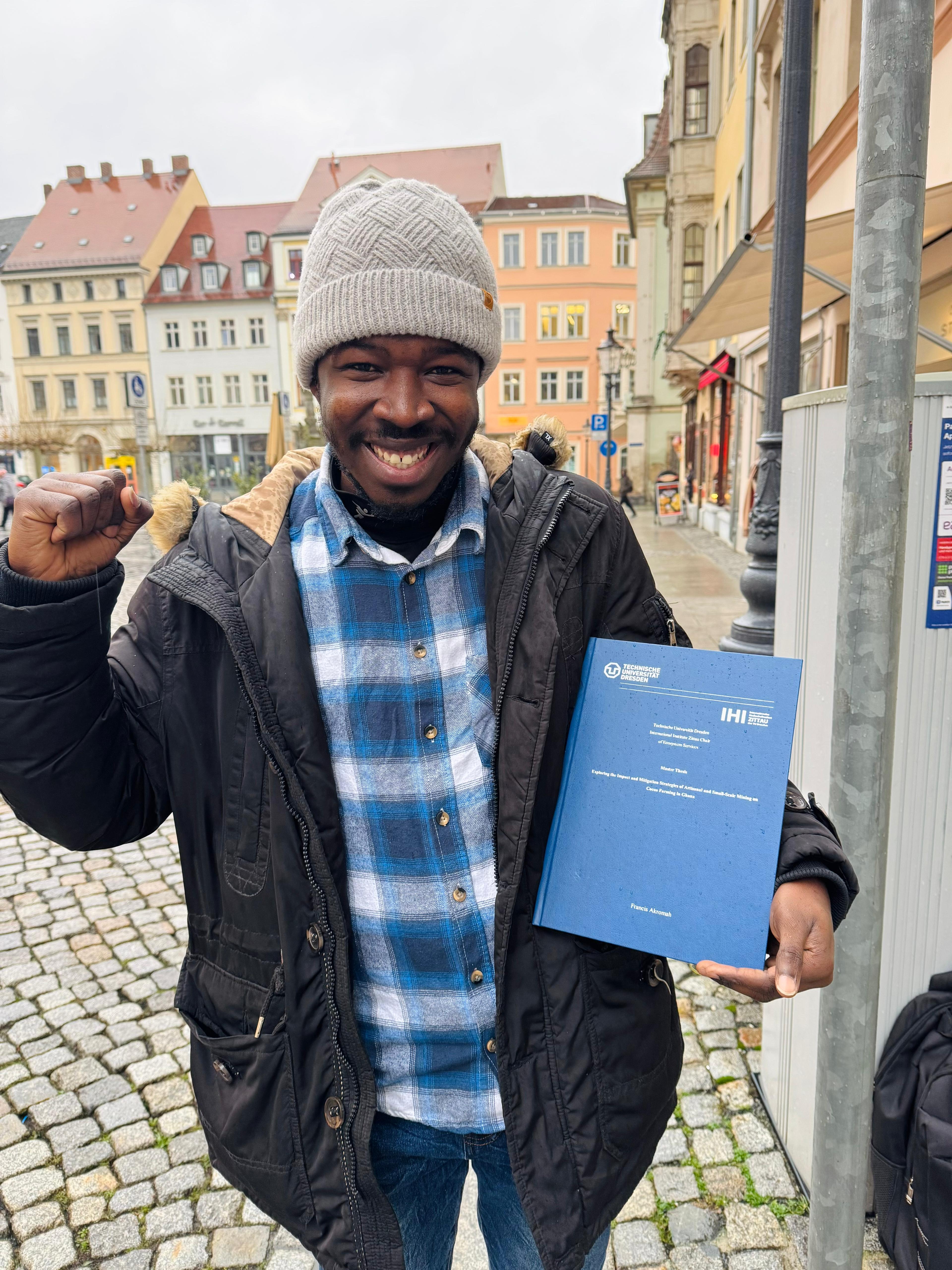 Three university graduates celebrating with diplomas raised